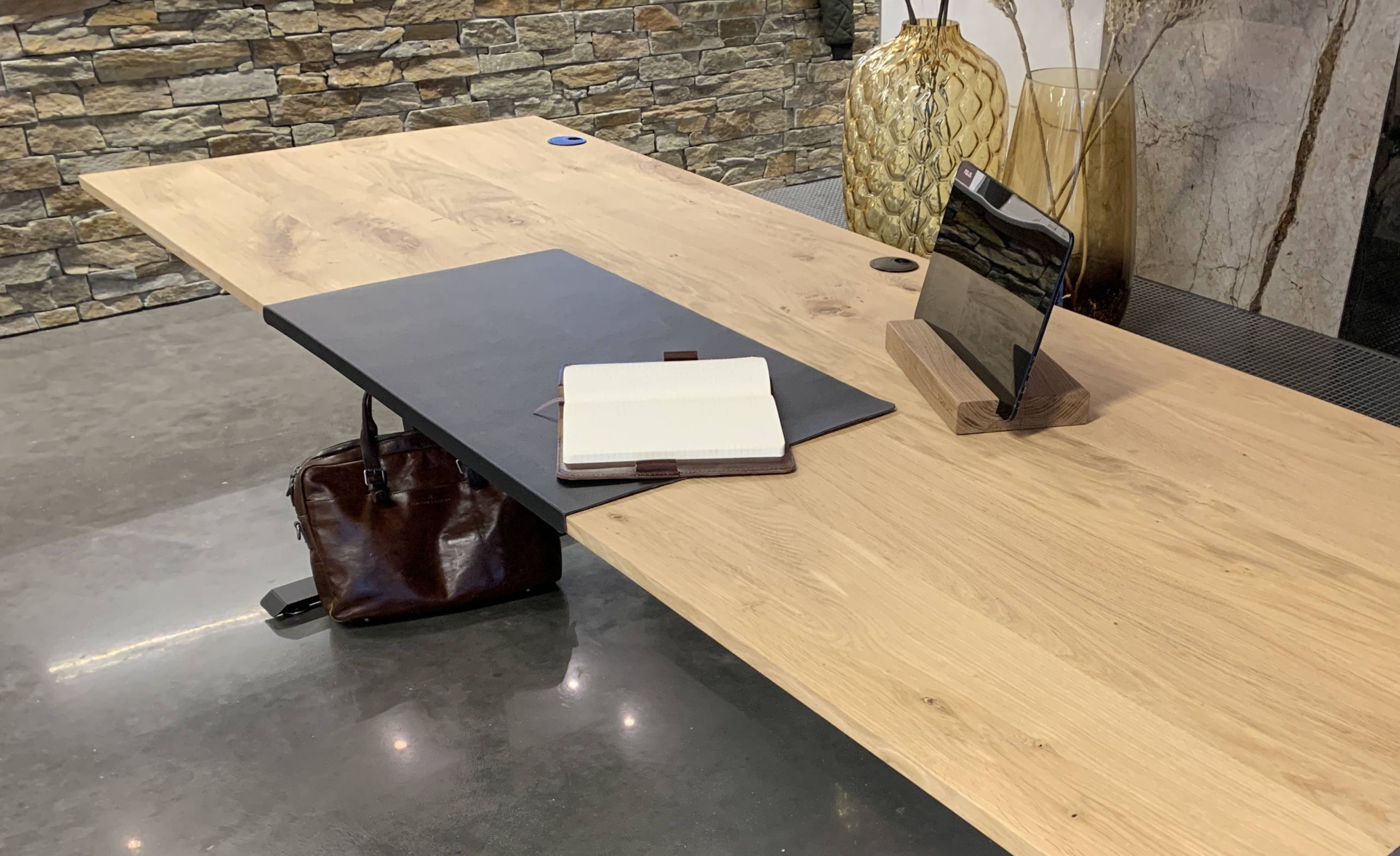 Blank eiken zit sta bureau met accessoires zoals leren tas en bureaulegger